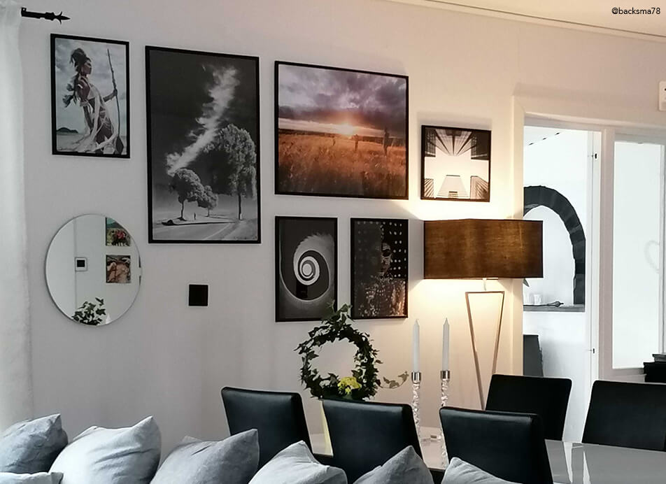 Parete di quadri con specchio e cornici nere