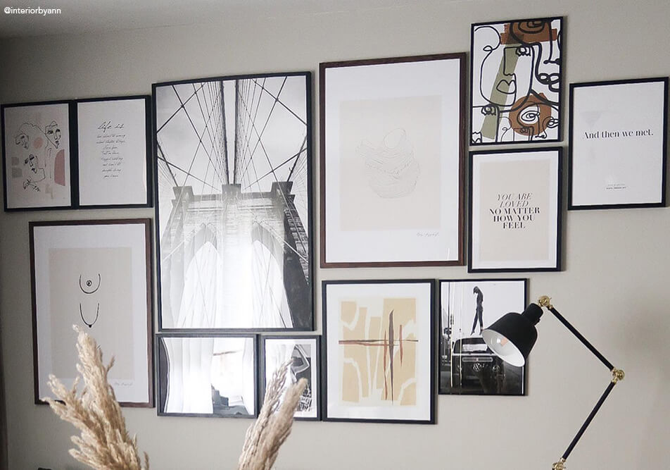 Grande parete di quadri sopra un divano in salotto