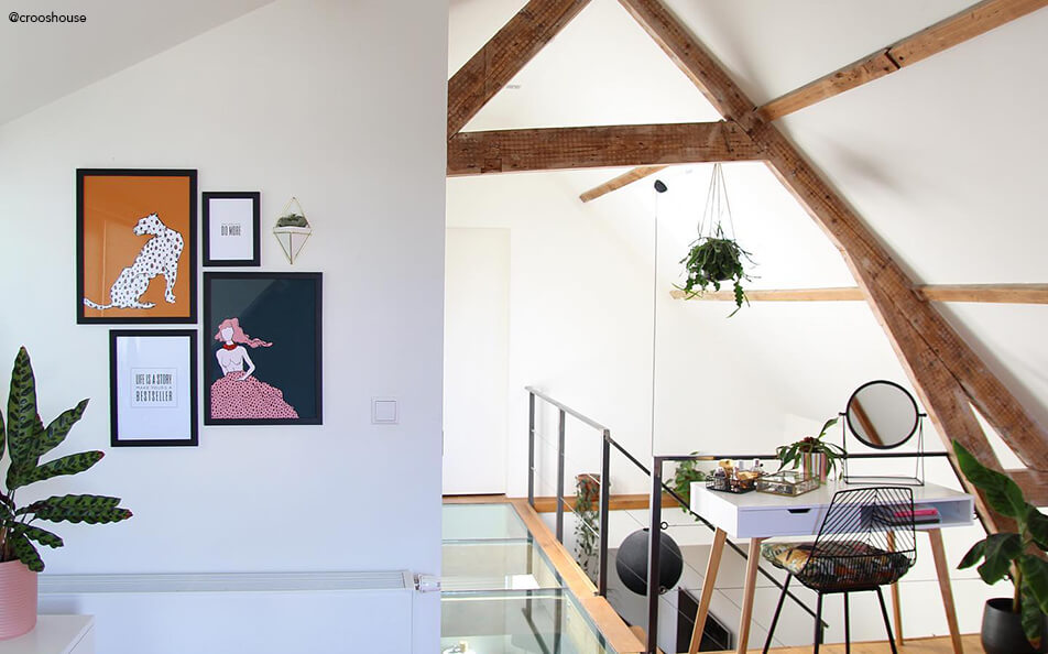 Parete di quadri in uno spazio piccolo - soffitto inclinato con travi